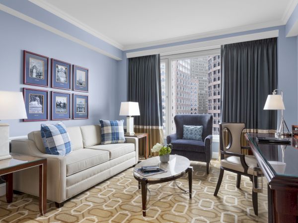 Elegant living room with sofas, lamps, coffee table, and city view.