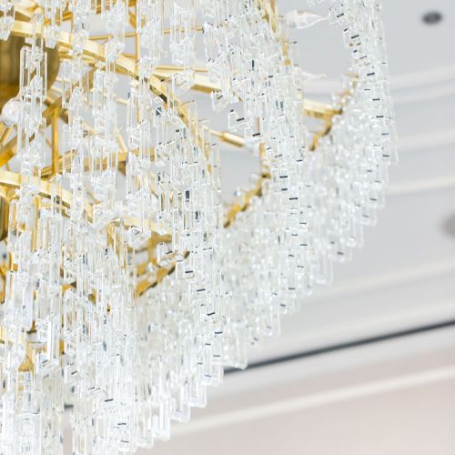 An ornate chandelier with crystal-like details and a gold structure is hanging from the ceiling, adding elegance to the space.