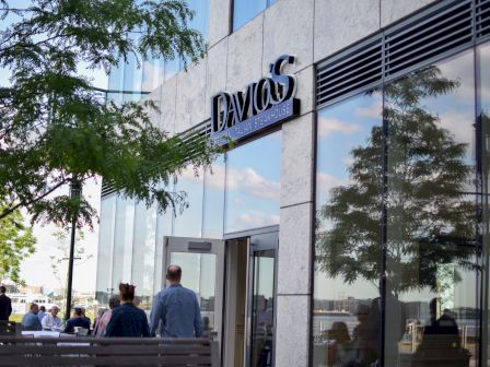 The image shows the exterior of a building with a sign reading "DAVIO'S", and people are entering or leaving through a glass door.