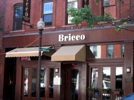 The image shows the exterior of a restaurant named "Bricco," with brown wooden decor, large windows, and an awning over the entrance.