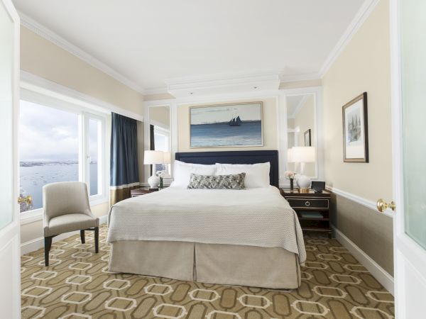 Elegant room with a large bed, artwork, and waterfront view.
