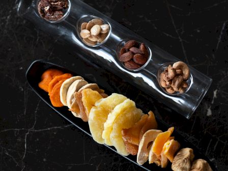 The image shows a variety of dried fruits and nuts organized neatly.