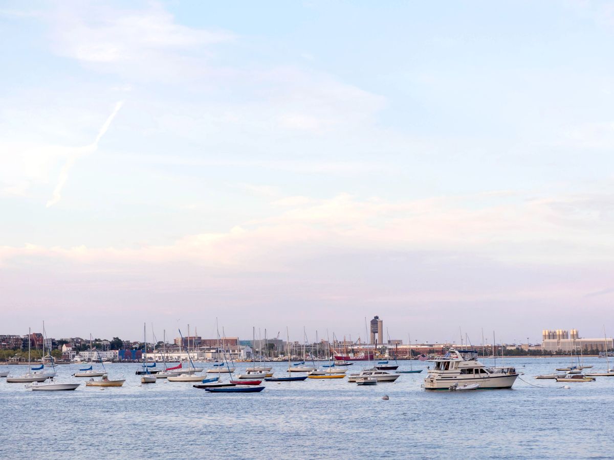 A harbor view with boats, buildings, and a dome structure near the water.