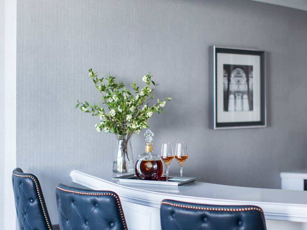 Elegant bar area with blue tufted chairs and a white table.