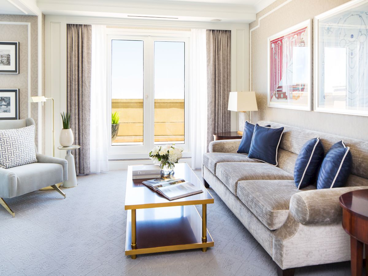 Elegant living room with sofa, chairs, table and ocean view through balcony doors