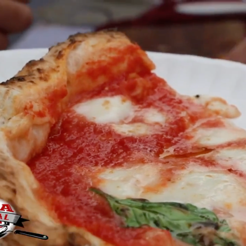 Close-up of a slice of Margherita pizza on a white plate, with a "Boston Pizza Festival" logo in the corner.