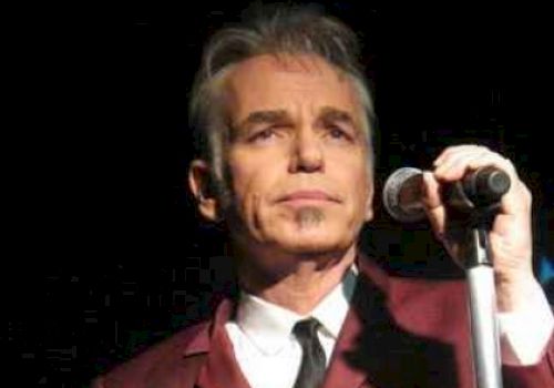 Billy Bob Thornton in a red suit at a microphone