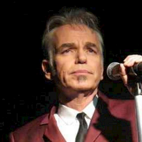 Billy Bob Thornton in a red suit at a microphone