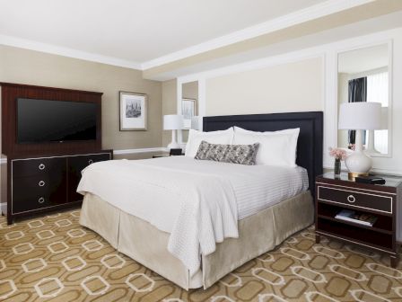 Elegant bedroom with a large bed, nightstands, and lamps.
