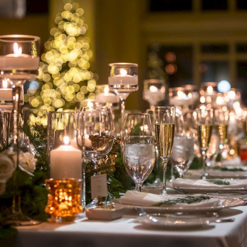 A beautifully set dinner table with candles, glassware, and festive decor, likely for a holiday or celebratory event.