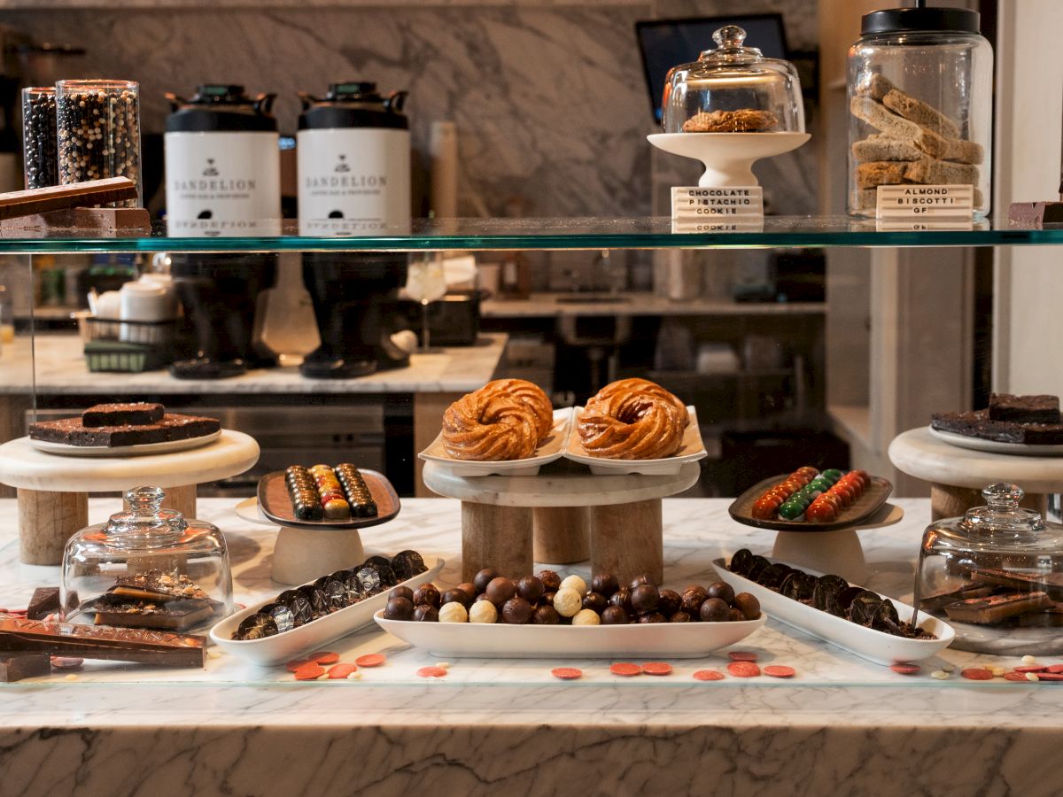 A dessert buffet display with chocolates, truffles, cookies, and assorted sweets arranged on tiered stands and glass jars.