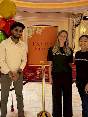 Three people pose near a 
